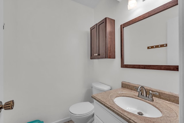 half bath with vanity, toilet, and baseboards