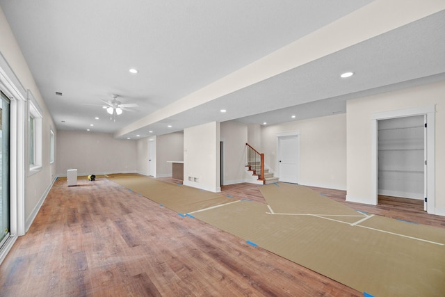 interior space featuring recessed lighting, light wood-style flooring, baseboards, and stairs