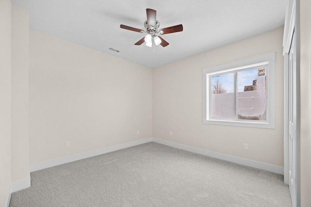 spare room with a ceiling fan, baseboards, and carpet flooring