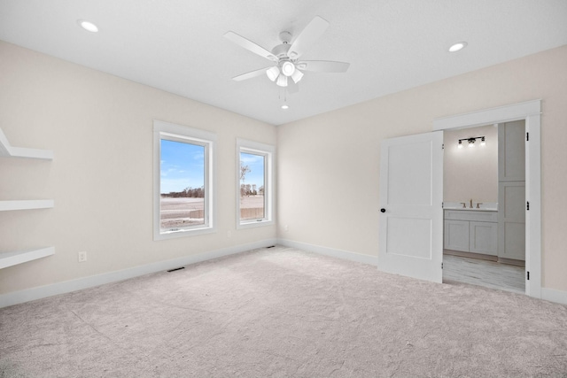 unfurnished bedroom featuring connected bathroom, recessed lighting, a sink, carpet flooring, and baseboards