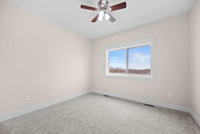 unfurnished room with ceiling fan, carpet floors, visible vents, and baseboards