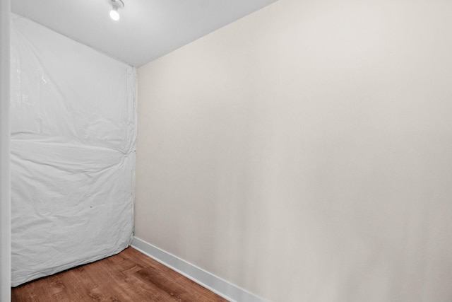 empty room featuring baseboards and wood finished floors