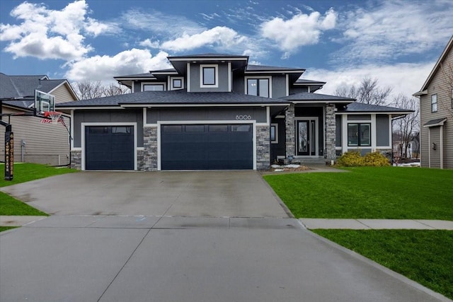 prairie-style house featuring stone siding, driveway, and a front yard