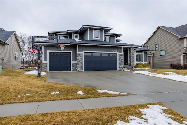 prairie-style home featuring a front lawn, concrete driveway, stucco siding, a garage, and stone siding