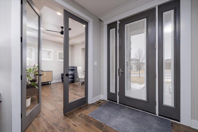 entryway with dark wood-style floors, french doors, and baseboards