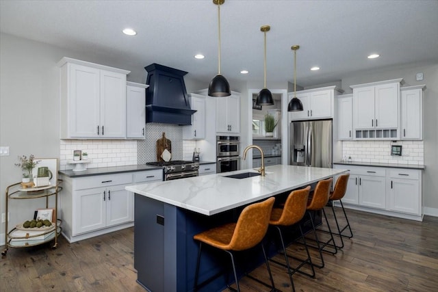 kitchen featuring custom exhaust hood, dark wood-style flooring, stainless steel appliances, and a sink