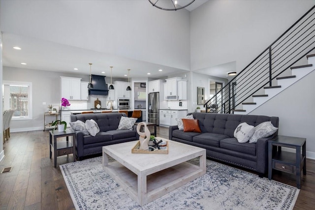 living room with stairway, recessed lighting, dark wood-style floors, and baseboards