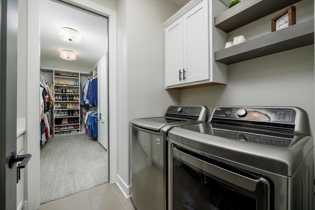 laundry area with light tile patterned flooring, cabinet space, and washing machine and clothes dryer