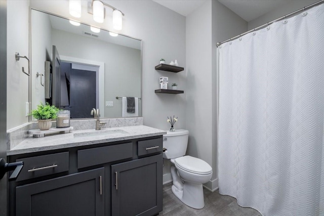 bathroom with visible vents, toilet, and vanity