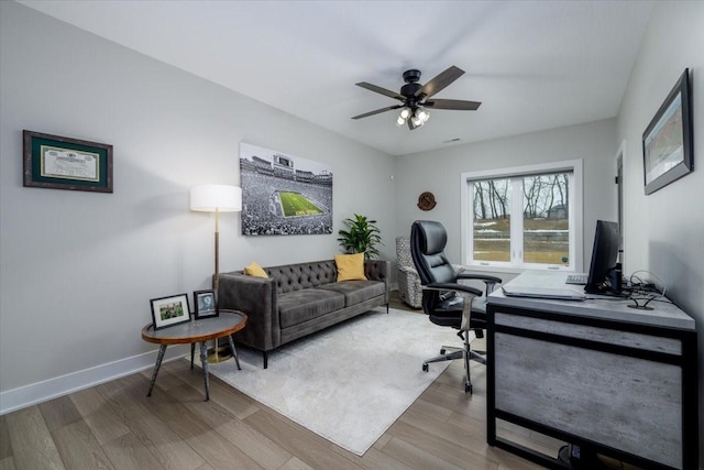 office space with a ceiling fan, wood finished floors, and baseboards