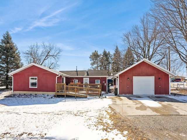 ranch-style house with a garage, driveway, and a deck