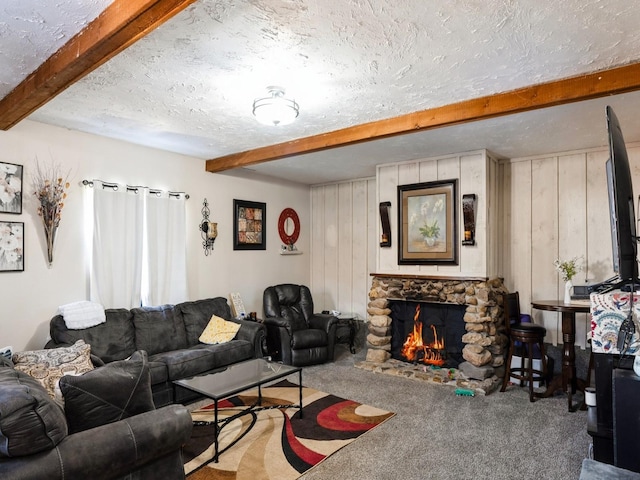 living area with carpet, a textured ceiling, beamed ceiling, and a stone fireplace