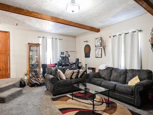 carpeted living room with beam ceiling and a textured ceiling