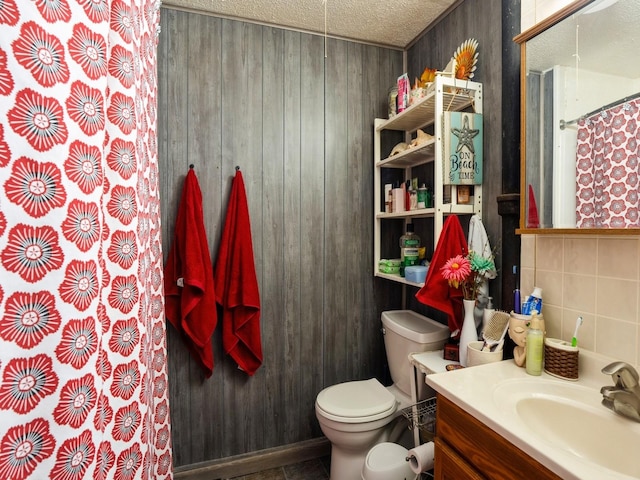 full bath with a shower with shower curtain, toilet, wood walls, a textured ceiling, and vanity