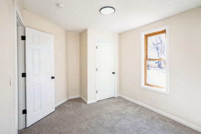 unfurnished bedroom with carpet flooring and baseboards