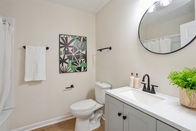 bathroom featuring baseboards, toilet, wood finished floors, curtained shower, and vanity