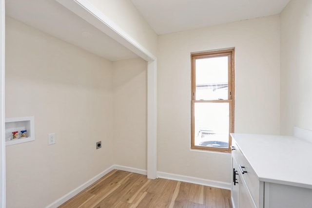 clothes washing area with light wood finished floors, cabinet space, baseboards, hookup for an electric dryer, and washer hookup