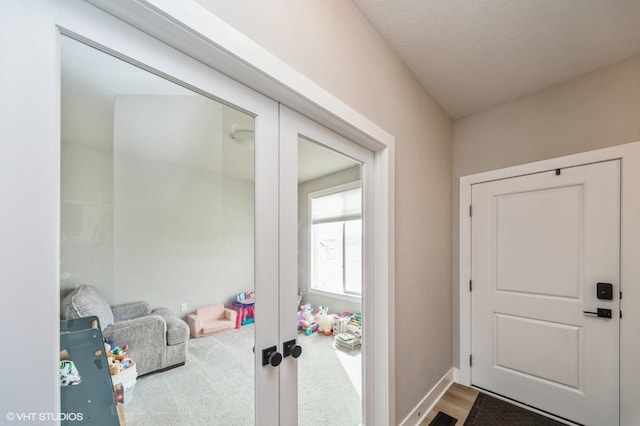 doorway with carpet flooring, french doors, and baseboards