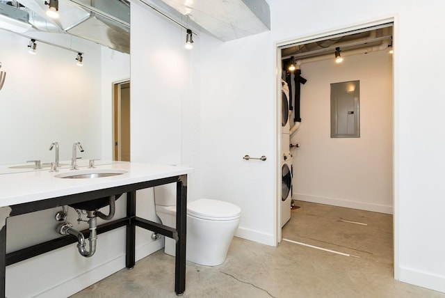 bathroom with concrete floors, toilet, electric panel, stacked washing maching and dryer, and a sink