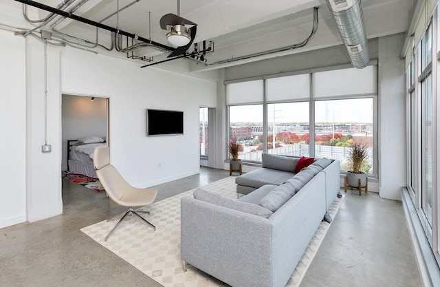 living room featuring baseboards and a towering ceiling