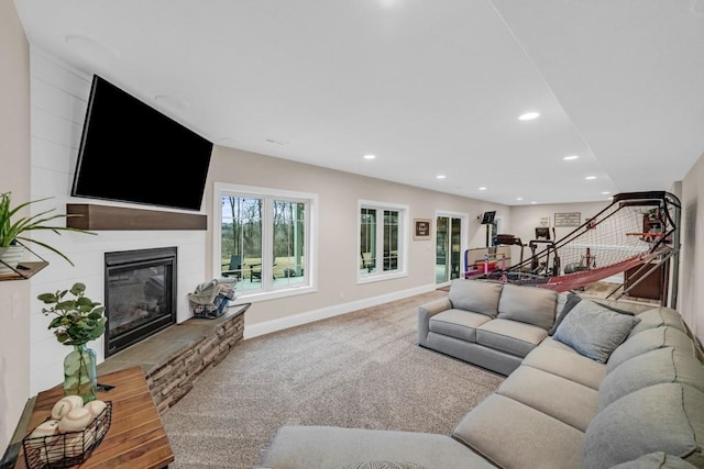 living room featuring baseboards, a glass covered fireplace, carpet, stairs, and recessed lighting