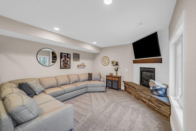 living area featuring carpet floors, a large fireplace, and recessed lighting