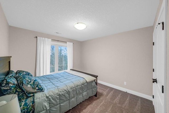 carpeted bedroom featuring a textured ceiling, visible vents, and baseboards