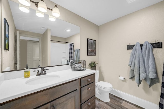 bathroom with toilet, wood finished floors, vanity, baseboards, and a shower with curtain