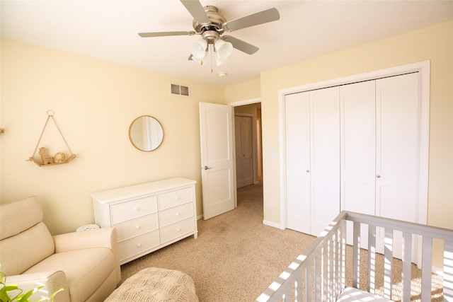 bedroom featuring light carpet, baseboards, visible vents, a ceiling fan, and a closet