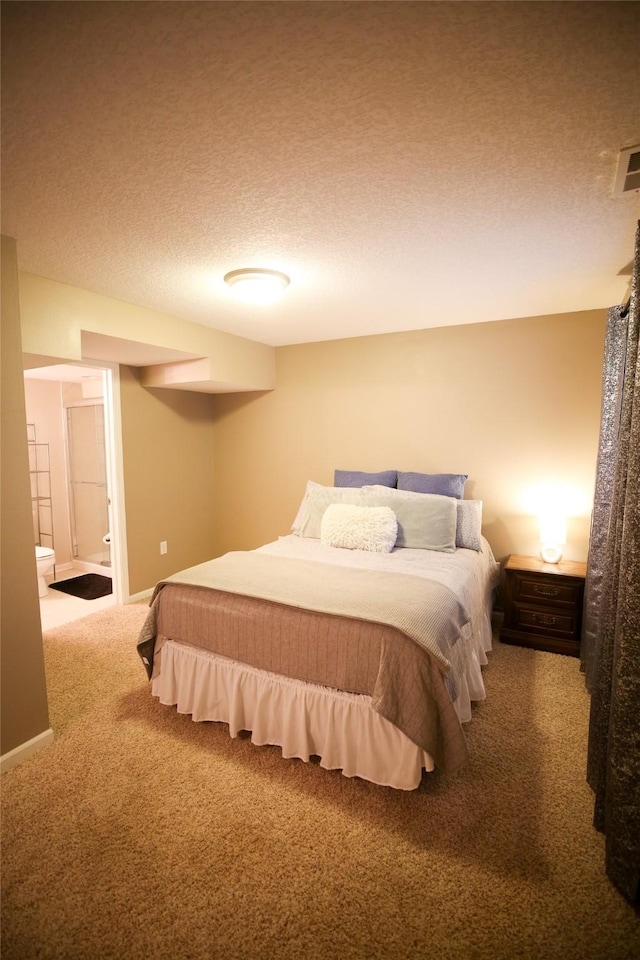 carpeted bedroom featuring a textured ceiling, connected bathroom, visible vents, and baseboards