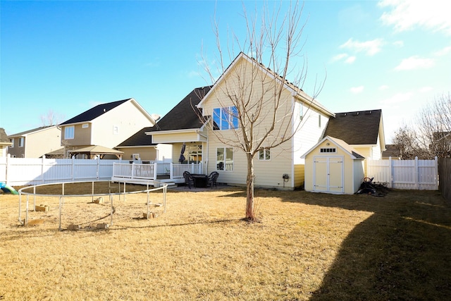 back of property with a fenced backyard, a storage unit, and an outdoor structure