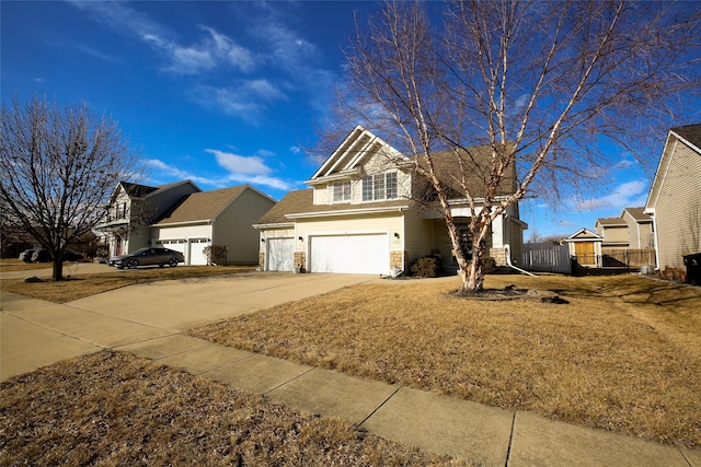 view of front of home featuring driveway, stone siding, fence, and a front yard