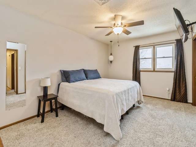 bedroom with light carpet, a ceiling fan, baseboards, and a textured ceiling