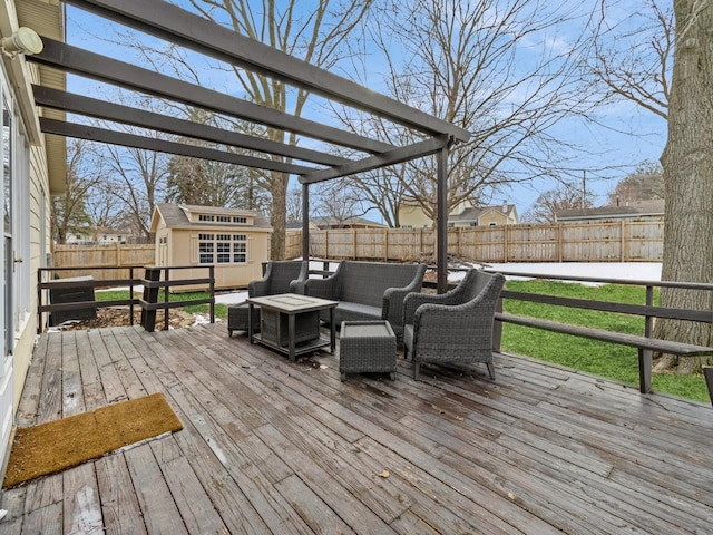 wooden deck with an outdoor living space, a fenced backyard, and an outdoor structure