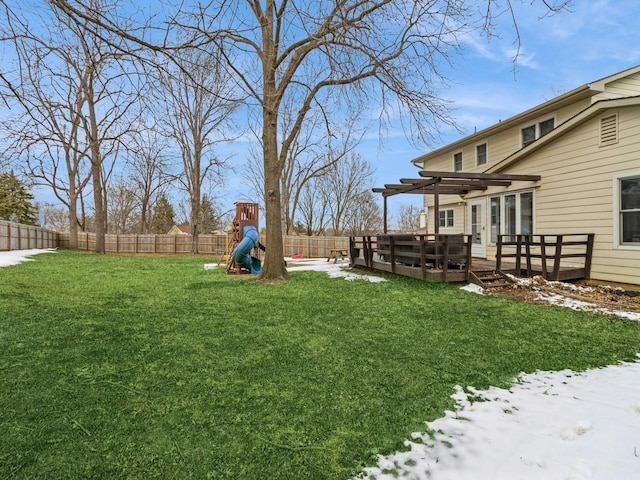 view of yard with a wooden deck, a fenced backyard, a pergola, and a playground