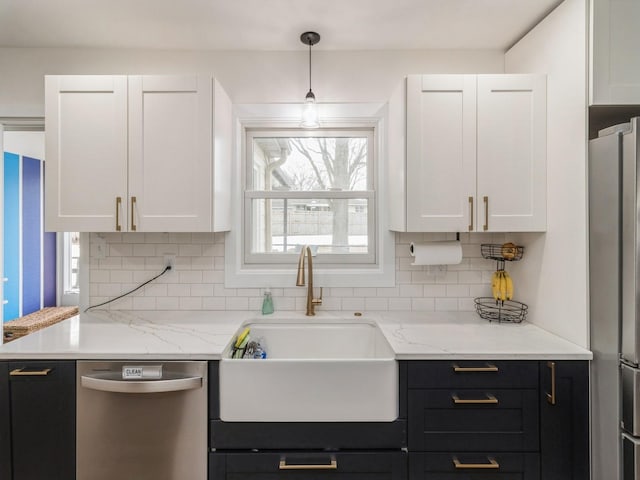 kitchen with a sink, white cabinetry, appliances with stainless steel finishes, decorative backsplash, and dark cabinets