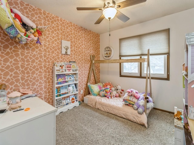 carpeted bedroom with baseboards, ceiling fan, an accent wall, and wallpapered walls