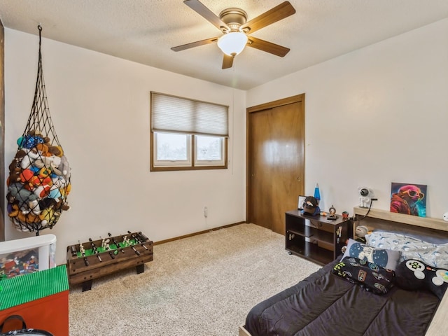 bedroom with a ceiling fan, a textured ceiling, a closet, carpet flooring, and baseboards