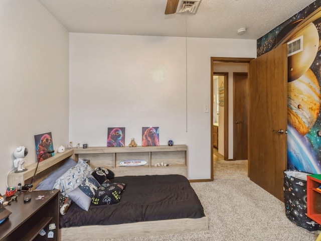 bedroom with visible vents, a textured ceiling, and carpet floors