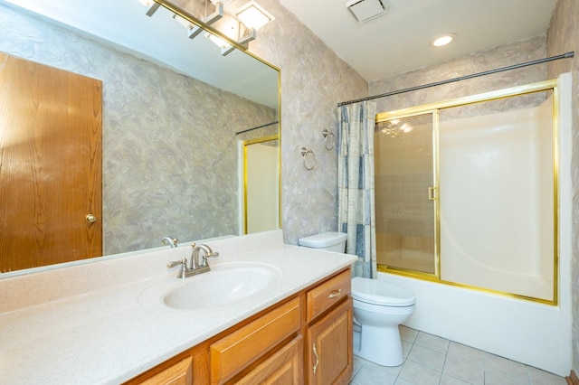 bathroom with shower / bath combination with glass door, vanity, toilet, and tile patterned floors