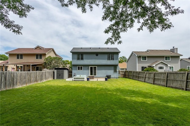 rear view of property with a fenced backyard and a lawn