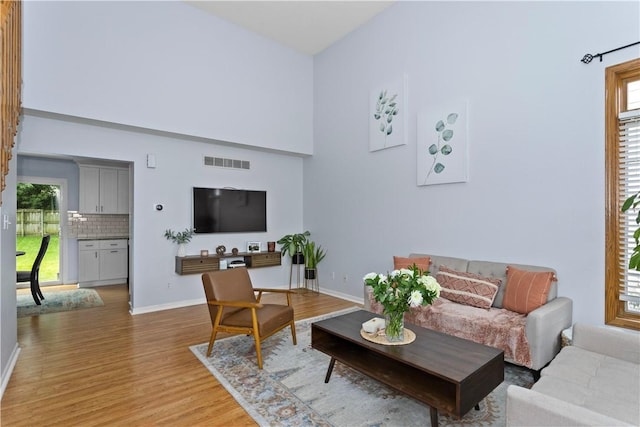 7014 Northview Dr, Urbandale, IA 50322 - living area featuring light wood-type flooring, baseboards, and a towering ceiling