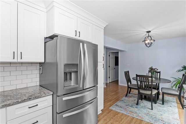 kitchen featuring light wood finished floors, backsplash, white cabinetry, and stainless steel fridge with ice dispenser