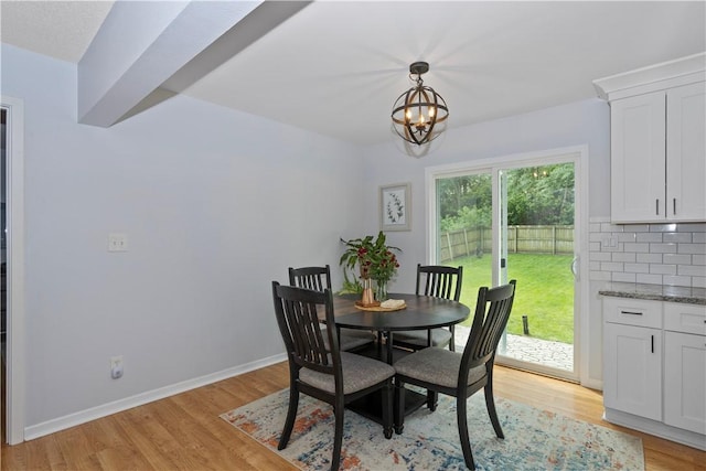 dining space with a chandelier, light wood finished floors, and baseboards