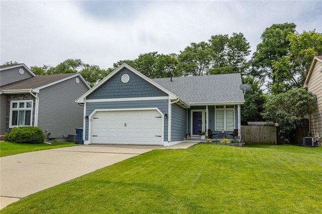 view of front of property featuring a garage, concrete driveway, a front lawn, and central AC unit