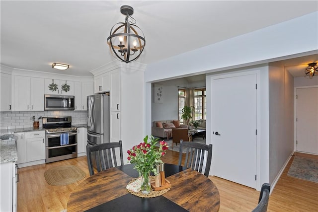 dining room featuring a chandelier and light wood-type flooring