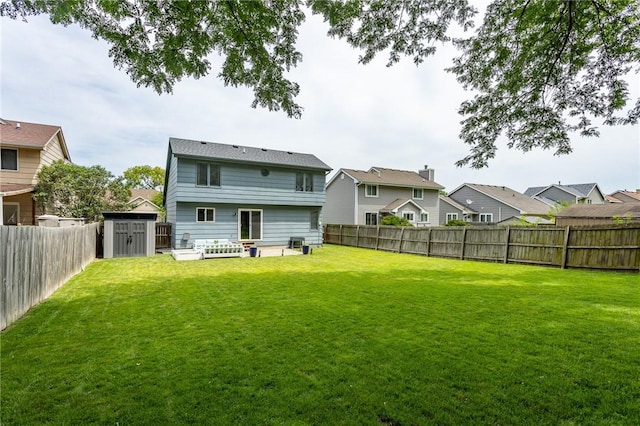 back of property with a fenced backyard, a residential view, and a yard