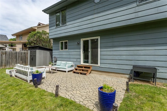 rear view of property with a patio, an outbuilding, fence, a yard, and outdoor lounge area
