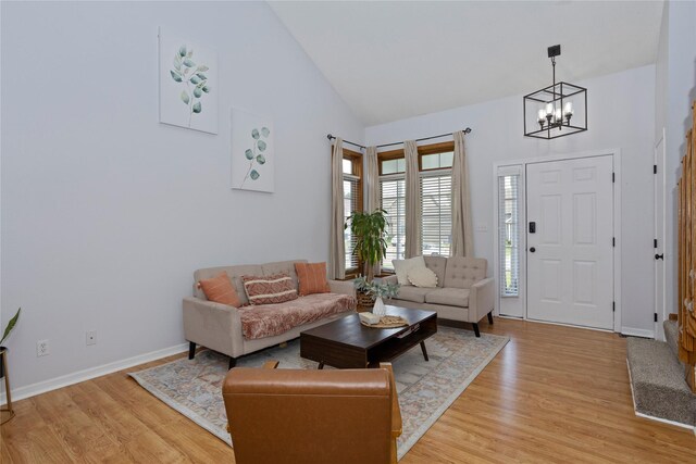 7014 Northview Dr, Urbandale, IA 50322 - living room featuring a chandelier, light wood-type flooring, and high vaulted ceiling