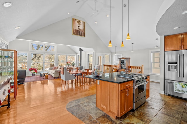 kitchen with dark countertops, plenty of natural light, light wood-type flooring, and high quality appliances